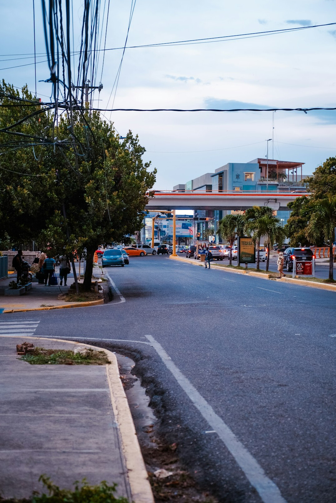 Group of commuters waiting at a bus stop in Santiago at dusk